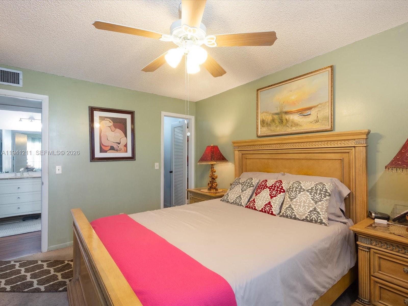414 Capri H, Unit 414 Delray Beach, FL 33484 - Photo 8 of 19 a bedroom with a bed and a chandelier