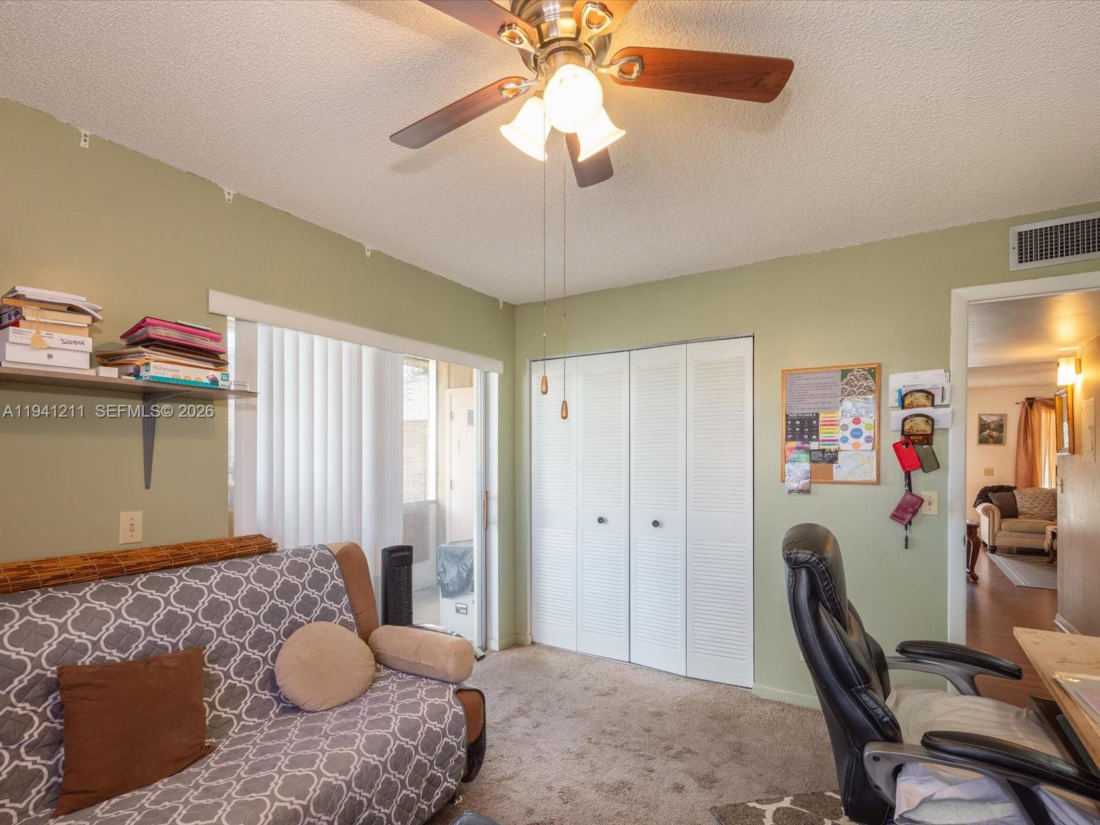 414 Capri H, Unit 414 Delray Beach, FL 33484 - Photo 9 of 19 a bedroom with a bed and a chandelier