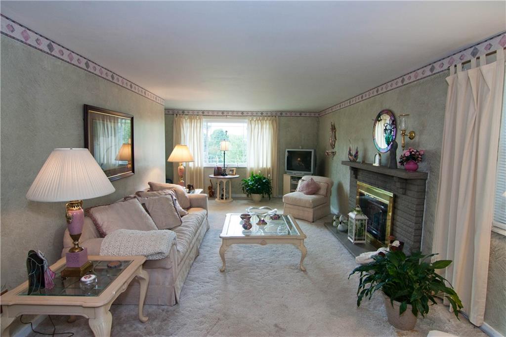 900 Rosalind Road Pittsburgh, PA 15237 - Photo 2 of 10 The 22x12 Living Room features wall to wall carpeting, though there is hardwood flooring beneath. Note the log-burning fireplace.