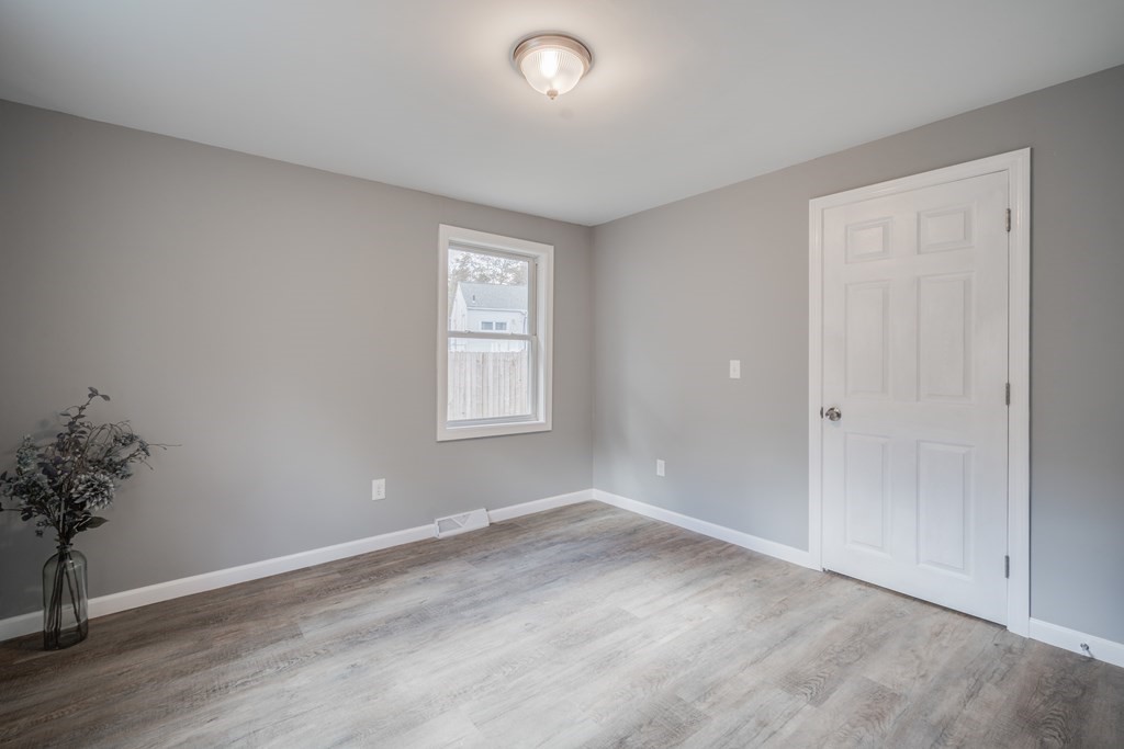 858 Bradley Road Springfield, MA 01109 - Photo 26 of 36 wooden floor in an empty room with a window