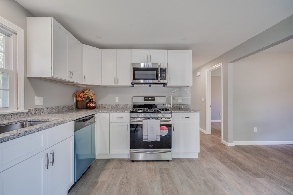 858 Bradley Road Springfield, MA 01109 - Photo 9 of 36 a kitchen with stainless steel appliances granite countertop a stove and white cabinets