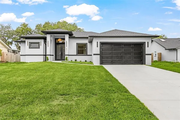a front view of a house with a yard and garage