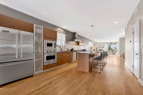 a kitchen with stainless steel appliances a dining table chairs stove microwave and cabinets