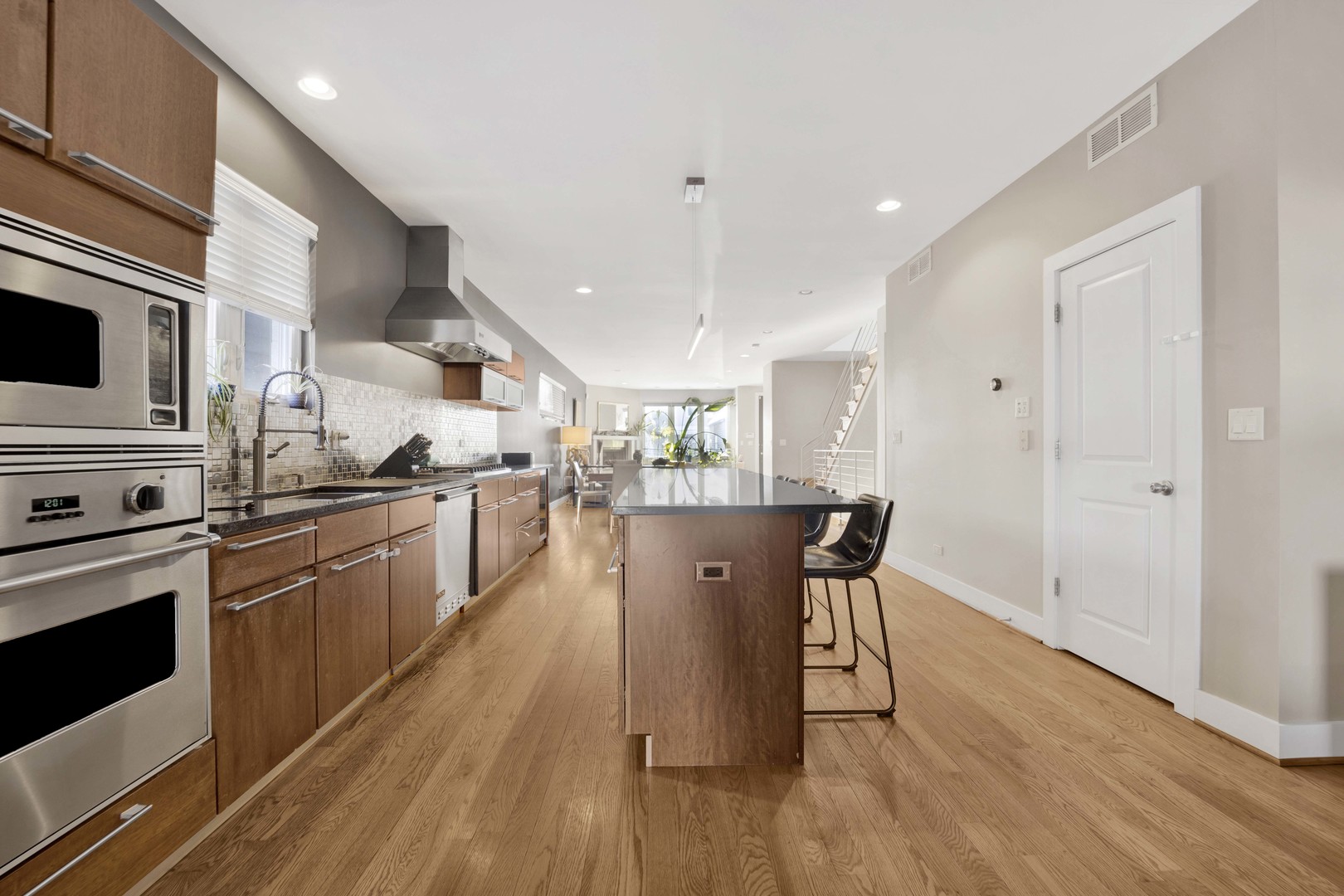 2648 West Homer Street Chicago, IL 60647 - Photo 15 of 49 a kitchen with stainless steel appliances a dining table chairs stove microwave and cabinets