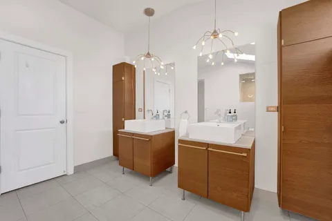 a bathroom with a double vanity sink a mirror and a bathtub