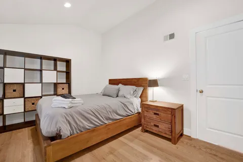 a bedroom with a bed and a lamp with the dresser