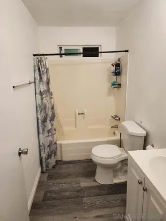 an empty room with wooden floor and cabinets