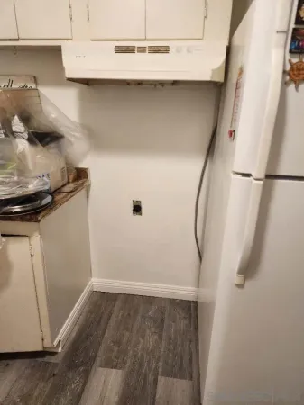a view of a room with wooden floor