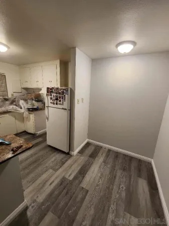 a view of a livingroom with wooden floor and a flat screen tv