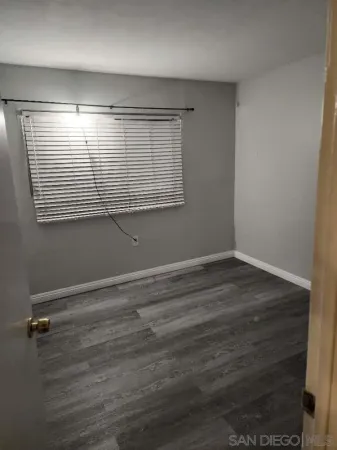 an empty room with wooden floor and entrance