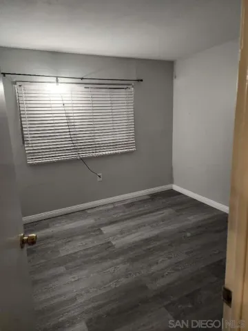 an empty room with wooden floor and entrance