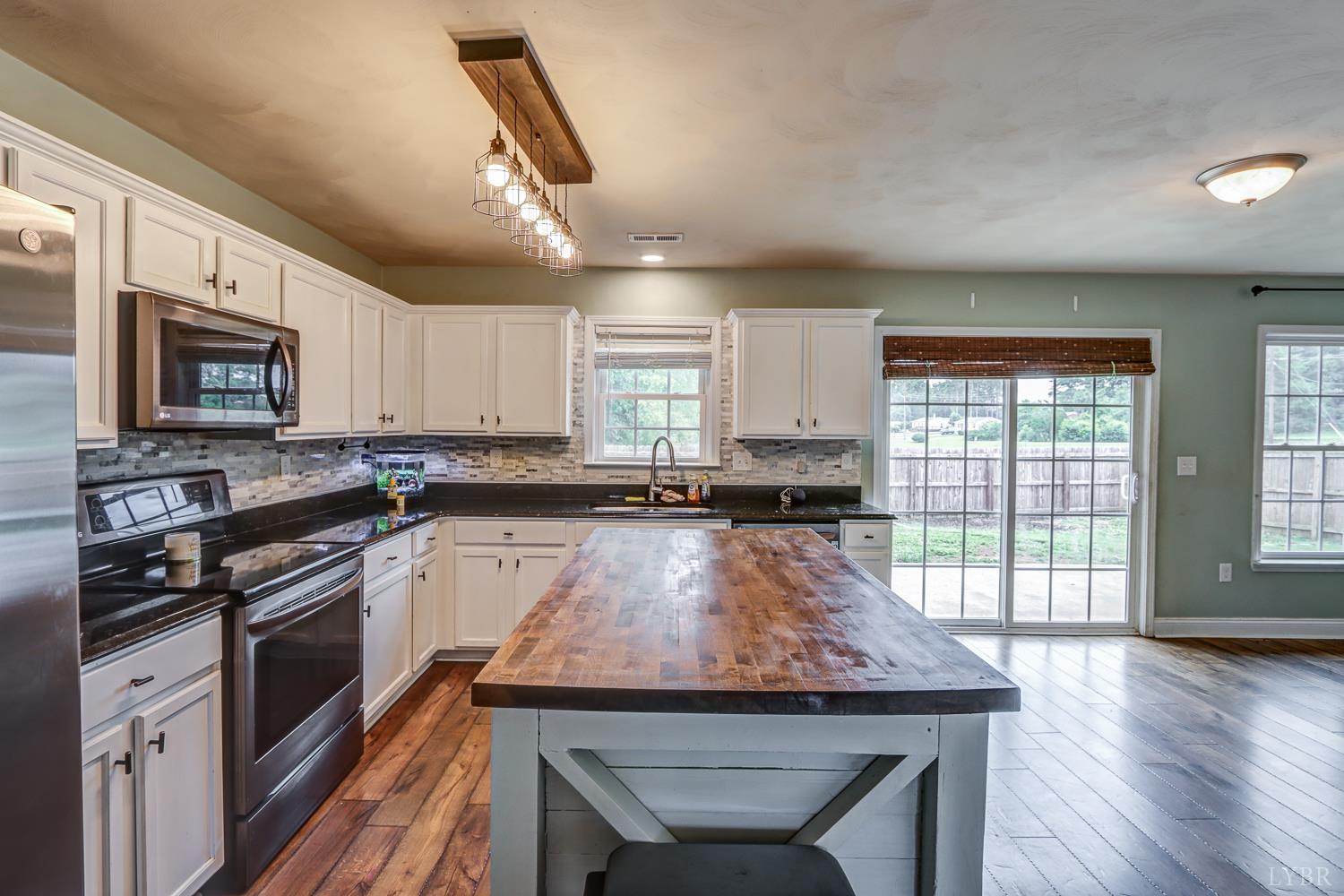 1057 Old Trail Road Forest, VA 24551 - Photo 14 of 49 a kitchen with granite countertop kitchen island stainless steel appliances a stove sink and microwave
