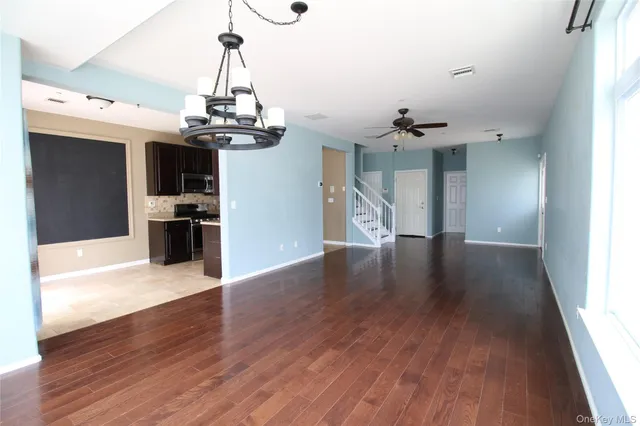 a view of a room with wooden floor kitchen view and a window
