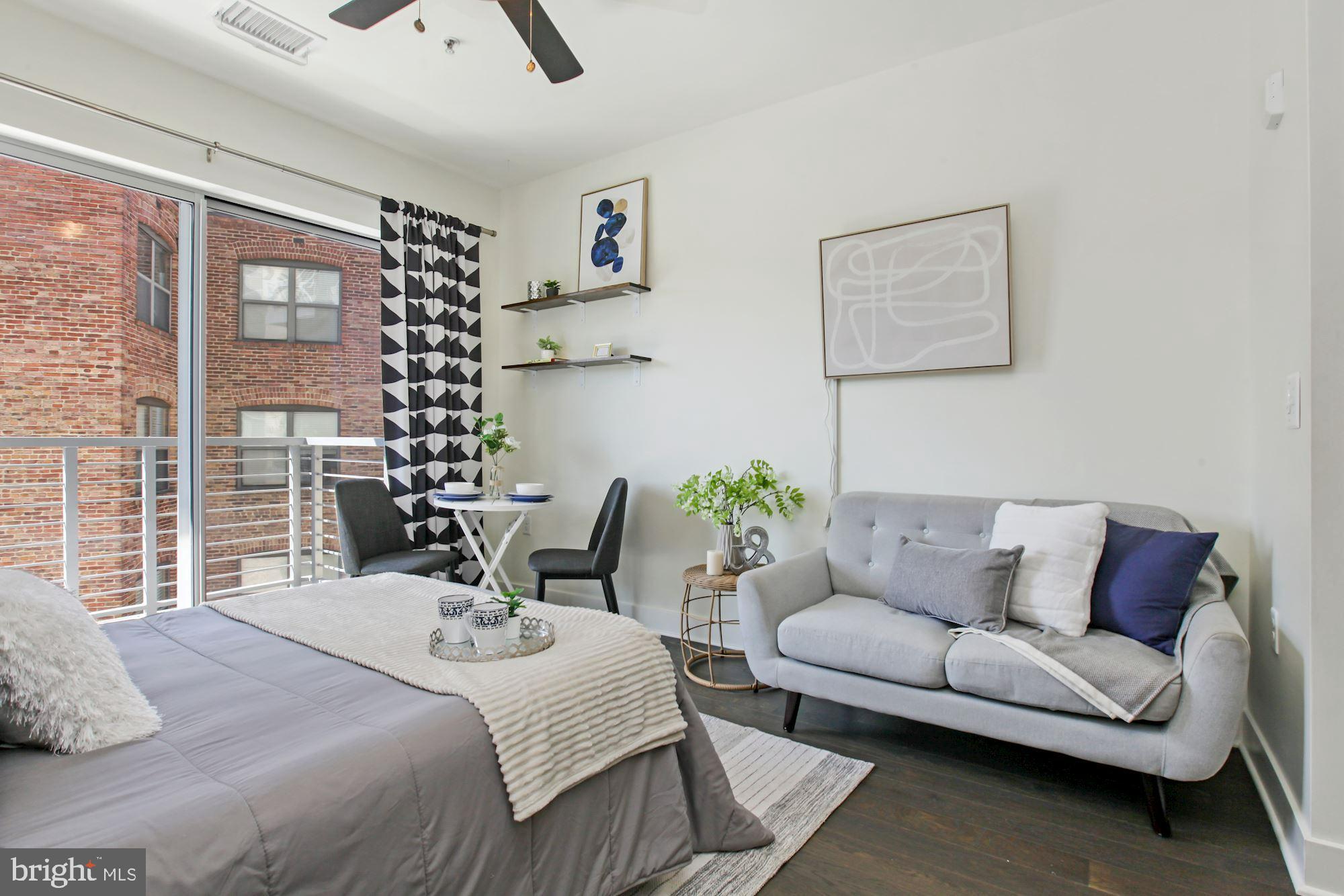2550 17th Street Northwest, Unit 302 Washington, DC 20009 - Photo 2 of 19 a bedroom with a bed a couch and a window