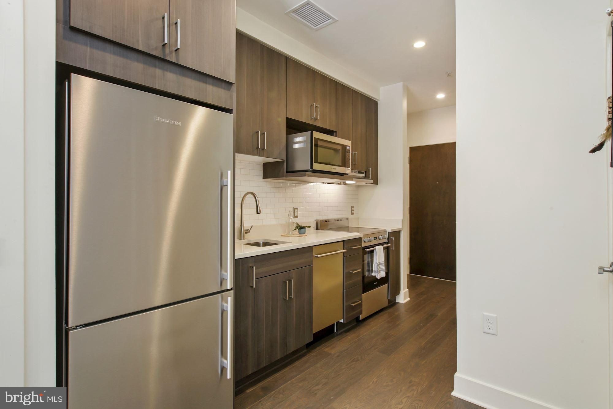 2550 17th Street Northwest, Unit 302 Washington, DC 20009 - Photo 6 of 19 a kitchen with stainless steel appliances a refrigerator a sink and a refrigerator