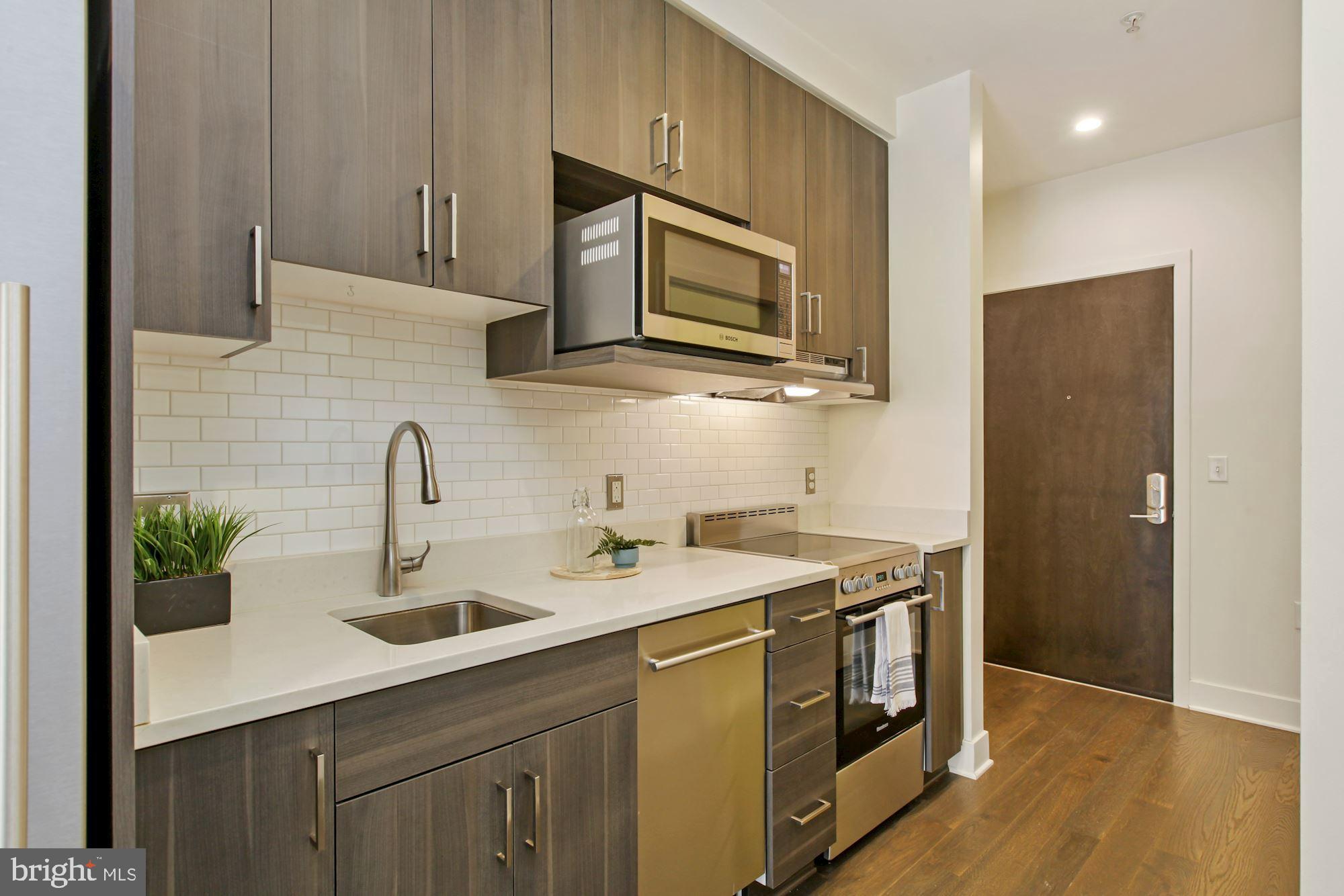 2550 17th Street Northwest, Unit 302 Washington, DC 20009 - Photo 7 of 19 a kitchen with stainless steel appliances granite countertop a sink and a microwave