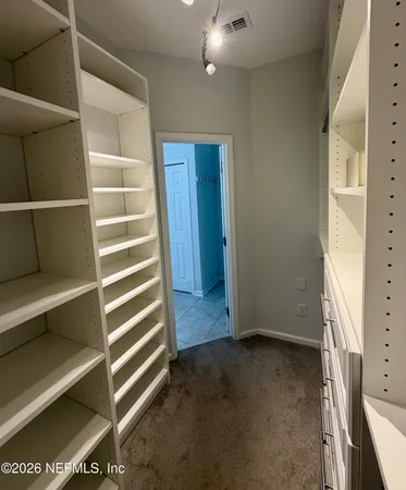 a view of walk in closet with empty racks