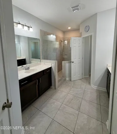 a large bathroom with a granite countertop sink a toilet a mirror and vanity