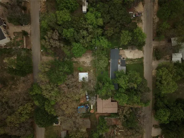 an aerial view of residential house with outdoor space and trees all around