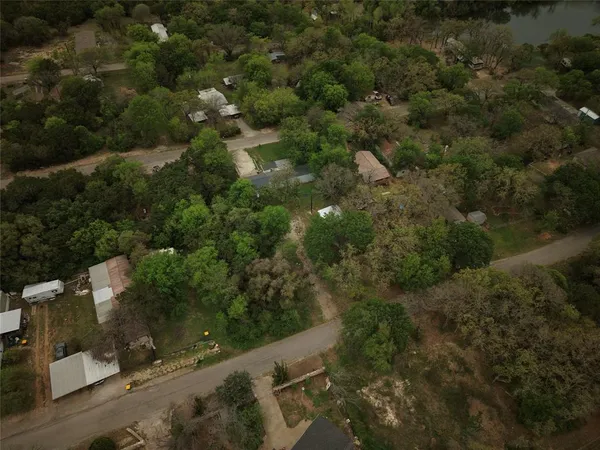 an aerial view of residential houses with outdoor space and trees