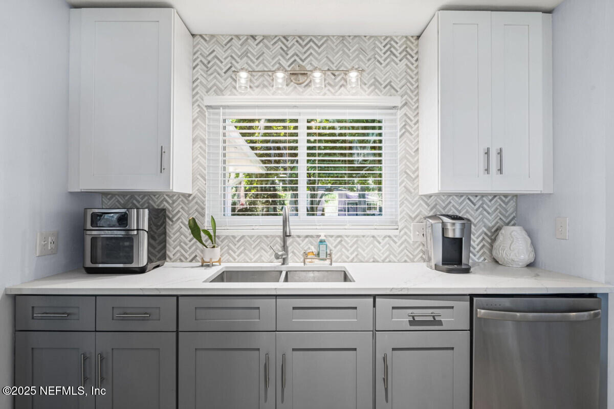 1901 Tanglewood Road Jacksonville Beach, FL 32250 - Photo 12 of 48 a kitchen with sink a window and cabinets