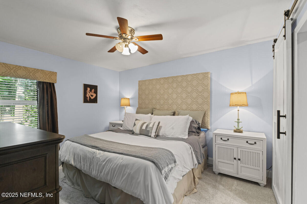 1901 Tanglewood Road Jacksonville Beach, FL 32250 - Photo 30 of 48 a bedroom with a bed and a chandelier