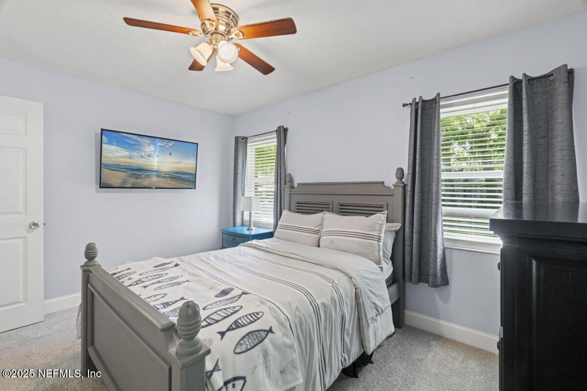 1901 Tanglewood Road Jacksonville Beach, FL 32250 - Photo 32 of 48 a bedroom with a bed and a chandelier