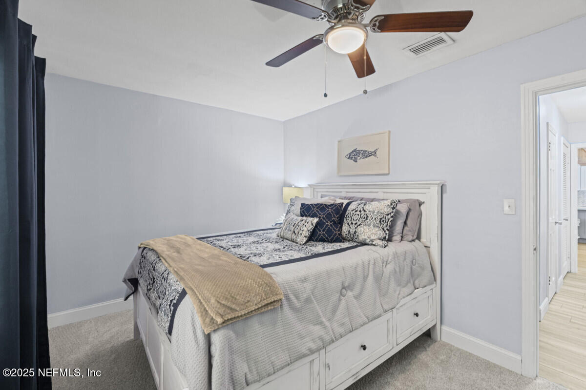 1901 Tanglewood Road Jacksonville Beach, FL 32250 - Photo 42 of 48 a bedroom with a bed and a chandelier