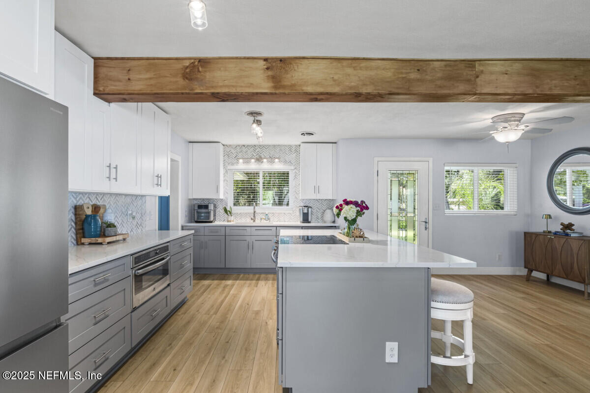 1901 Tanglewood Road Jacksonville Beach, FL 32250 - Photo 10 of 48 a kitchen with stainless steel appliances a microwave a stove a sink dishwasher and cabinets with wooden floor