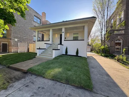 a front view of a house with a garden and yard