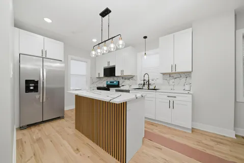 a kitchen with kitchen island granite countertop appliances cabinets and a counter top space