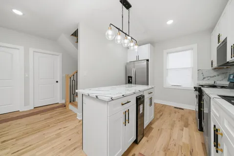 a kitchen with a stove and a wooden floor