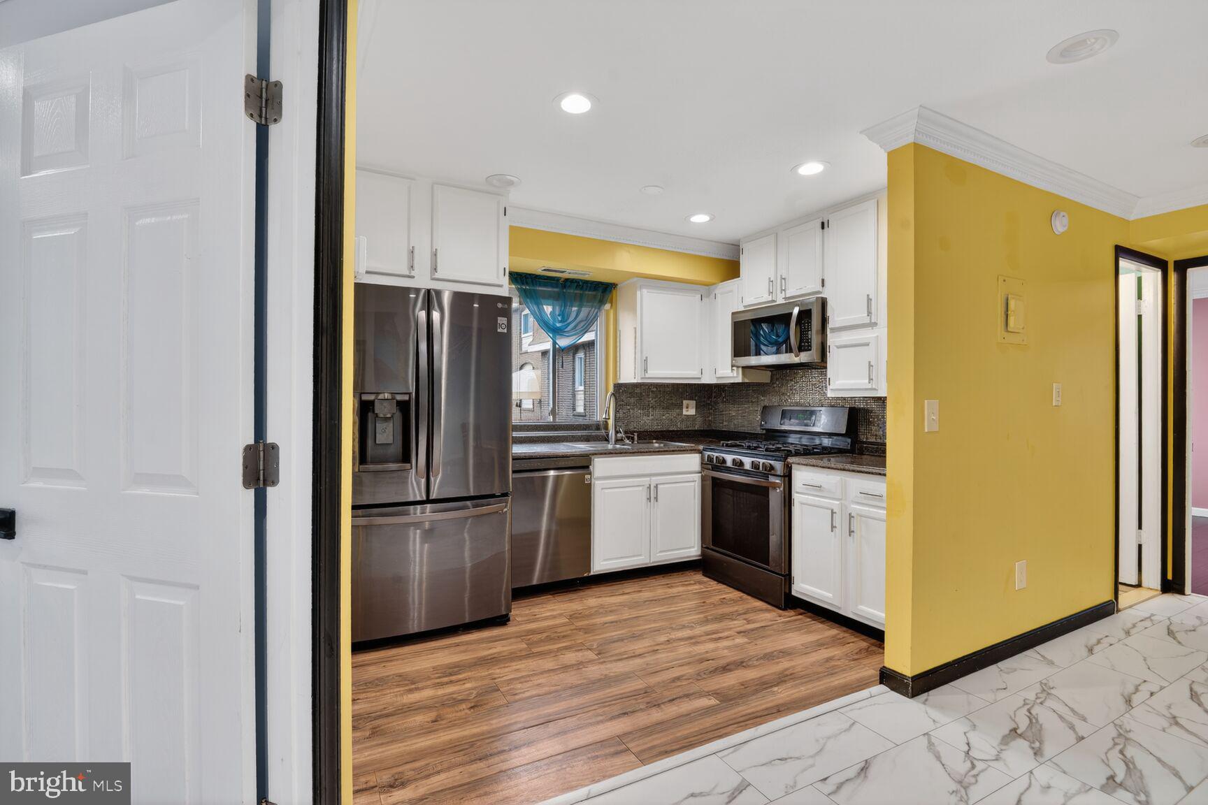 11903 E Tarragon Road, Unit E Reisterstown, MD 21136 - Photo 4 of 13 a kitchen with a refrigerator stainless steel appliances wooden floor cabinets and a counter top space