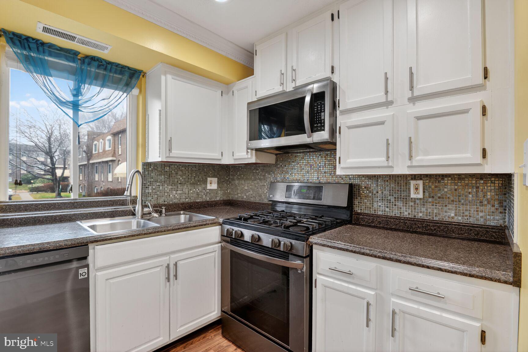 11903 E Tarragon Road, Unit E Reisterstown, MD 21136 - Photo 5 of 13 a kitchen with stainless steel appliances granite countertop white cabinets a sink and dishwasher