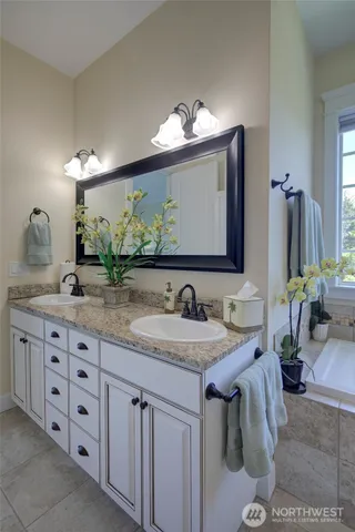 a bathroom with double vanity sinks and a mirror
