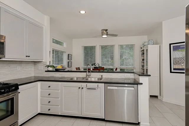 a kitchen with granite countertop white cabinets and white appliances