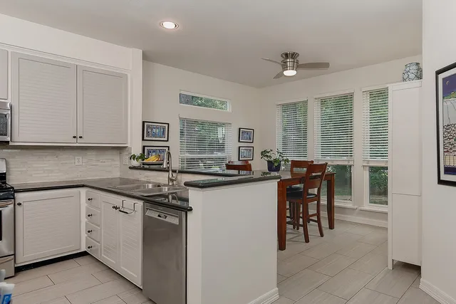 a kitchen with stainless steel appliances granite countertop a sink and a refrigerator