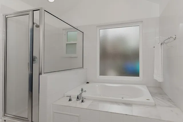 a spacious bathroom with a mirror sink and glass door