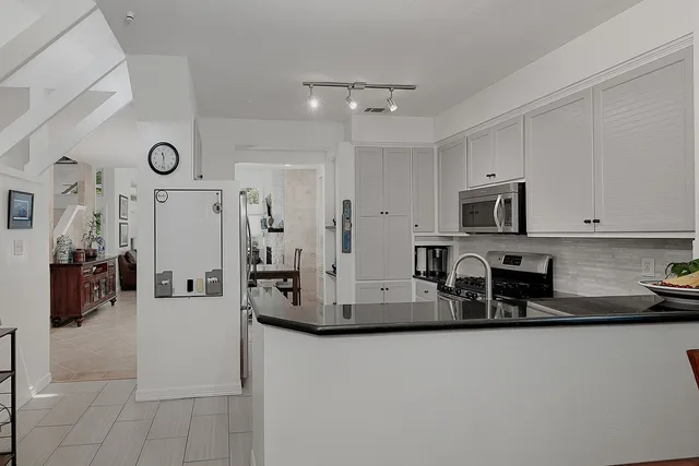 a kitchen with stainless steel appliances granite countertop a refrigerator and microwave