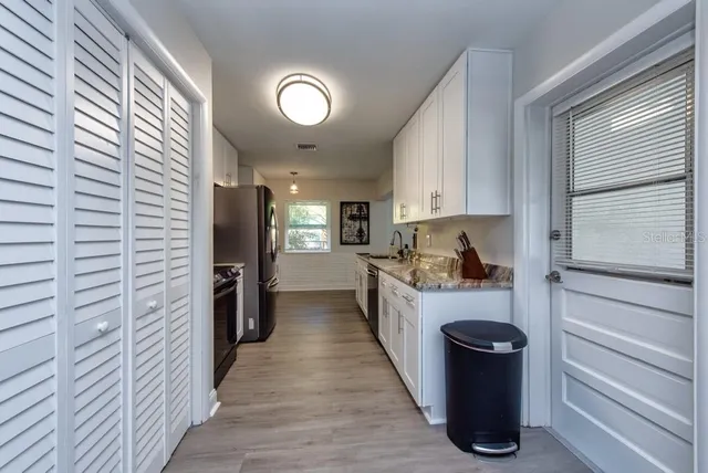 a kitchen with refrigerator and cabinets