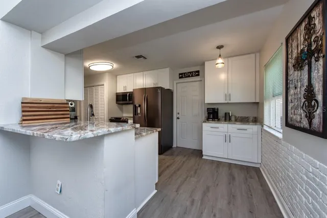 a kitchen with refrigerator and cabinets