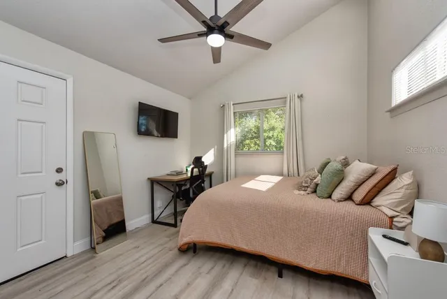 a bedroom with a bed and a flat tv screen on dresser