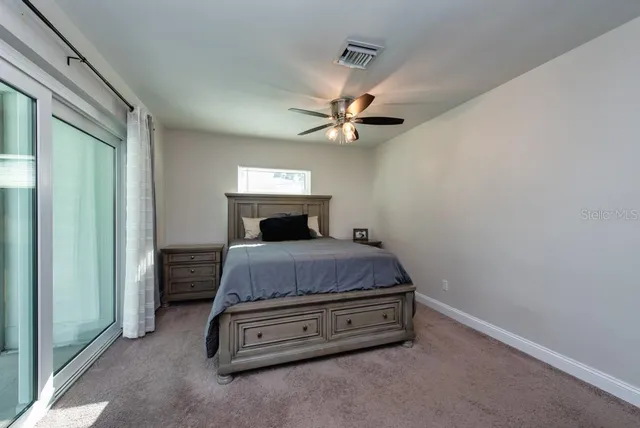 a bedroom with a bed and a ceiling fan