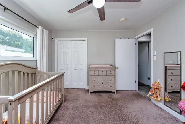 a view of a bedroom with furniture window and a ceiling fan