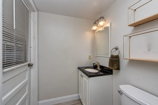 a bathroom with a sink a toilet and a mirror