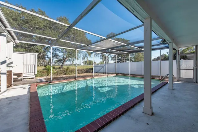 a view of a backyard with a small deck and wooden chairs
