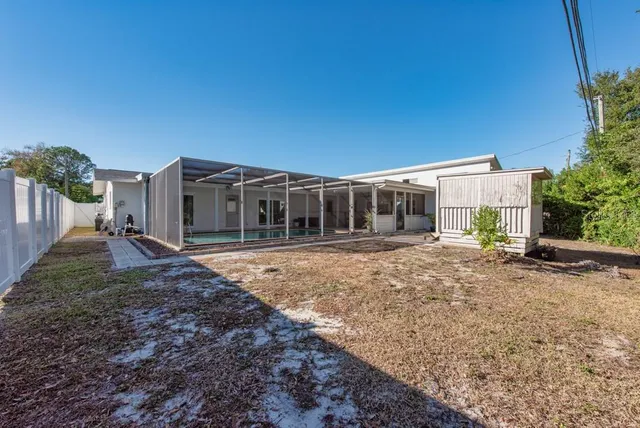a view of house with backyard and glass windows
