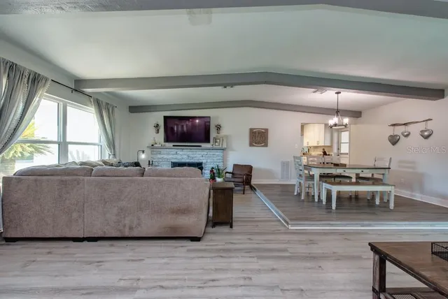a living room with furniture a dining table and a fireplace