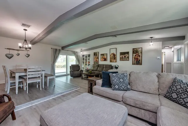 a living room with furniture dining area and a chandelier