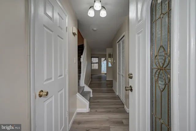 a view of a hallway with wooden floor and staircase